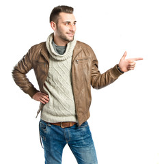 Young man pointing to his right over white background