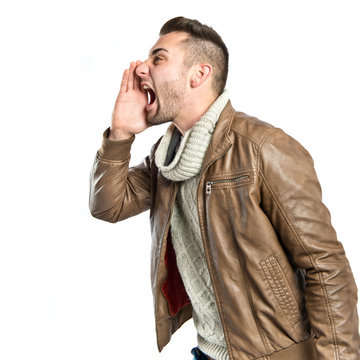 Young man screaming over isolated white background