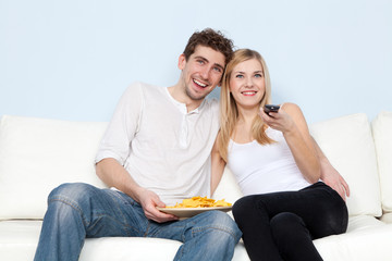 Obraz premium Young beautiful couple on a sofa at home