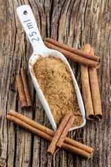 Ground cinnamon spice ,and cinnamon barks, old wood background