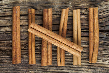 Seven cinnamon barks on the old wood background