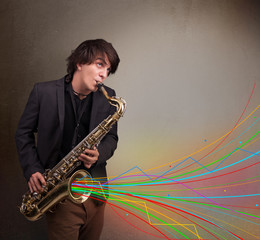 Naklejka premium Attractive musician playing on saxophone while colorful abstract
