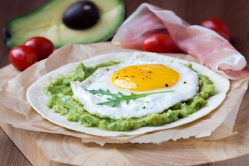 Breakfast with fried egg and sauce of avocado on grilled flour