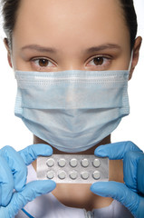 Doctor in blue gloves holding packs of pills