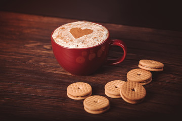 Cup of coffee decorated with heart and cookies.