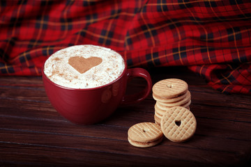Cup of coffee decorated with heart and cookies.