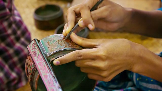 Burma. Artist makes pattern on the product in the workshop