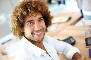 Handsome smiling businessman in front of desktop