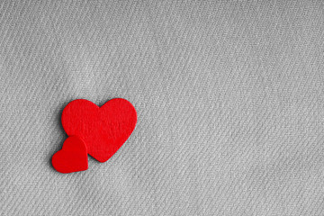 Obraz premium Red wooden decorative hearts on gray cloth background.