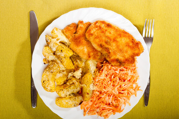 Dinner meal. Fried chicken roasted potatos and carrot salad.