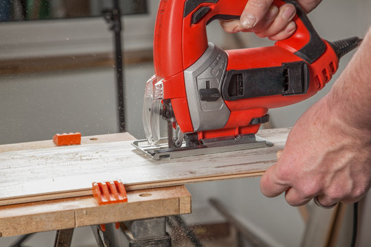 A Craftsman is sawing a Laminate panel.