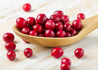 Cranberries in a  wooden spoon