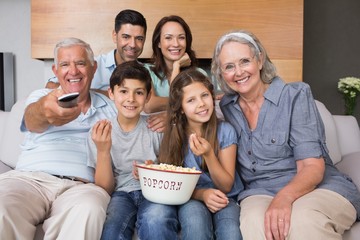 Obraz premium Portrait of happy extended family watching tv in living room