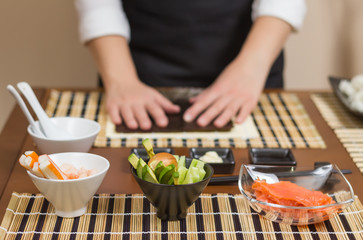 Obraz na płótnie Canvas Woman chef ready to prepare japanese sushi rolls