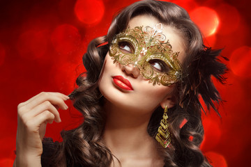 Young beautiful woman in golden carnival mask.