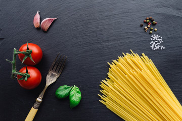 Pasta ingredients on black slate background