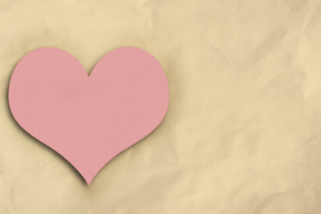 Fototapeta premium Pink heart on crumpled paper background