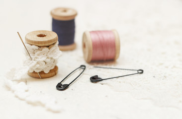 Sewing background. Spool of thread, lace and pins