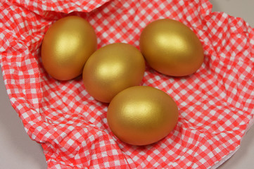 four golden eggs in a patterned napkin