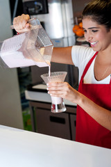 Girl filling glass with strawberry shake