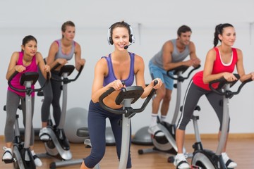 Fototapeta na wymiar Fit people working out at spinning class
