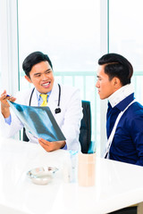 Asian doctor showing X-ray photography