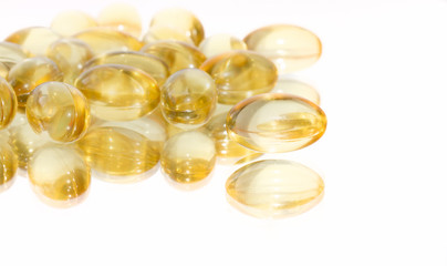 Cod liver oil capsules on a white mirrored background