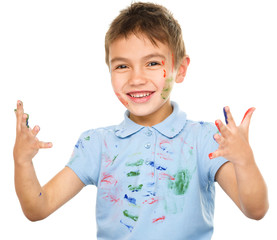 Portrait of a cute boy playing with paints