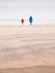 woman  and small girl on winter beach
