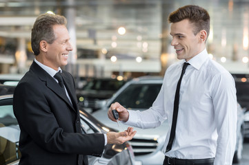 Giving a key of a brand new car.