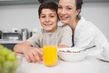 Smiling mother with son at breakfast table in kitchen