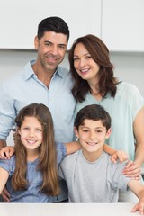 Portrait of a happy family of four in kitchen