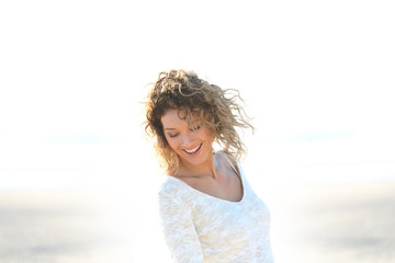 Fototapeta na wymiar Beautiful smiling blond woman standing on a beach