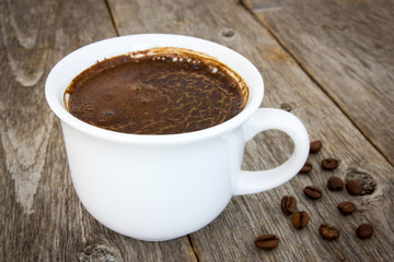 Black coffee and beans on the wooden floor