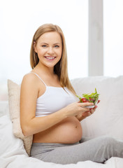 happy pregnant woman with bowl of salad