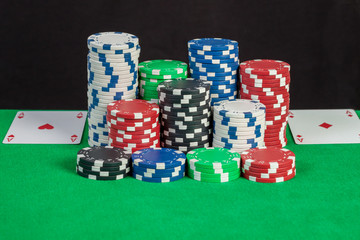 pair aces and poker chips stack on green table