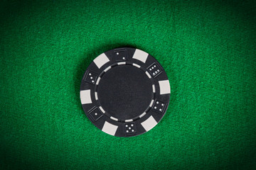 macro black poker chip on green table