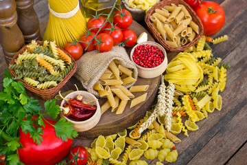 Variety of uncooked pasta and vegetables