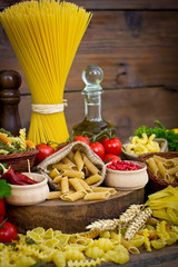 Variety of uncooked pasta and vegetables