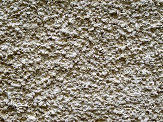 Gray plastered stone wall with grained texture.
