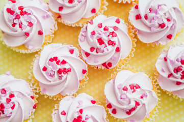 Cupcakes with pink cream and heart sprinkles
