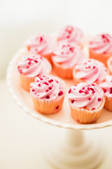 Cupcakes with pink cream and heart sprinkles