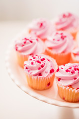 Cupcakes with pink cream and heart sprinkles
