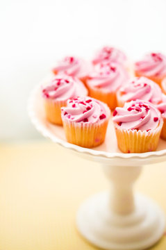 Cupcakes with pink cream and heart sprinkles