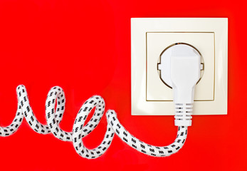 Power cord and power socket against a red background