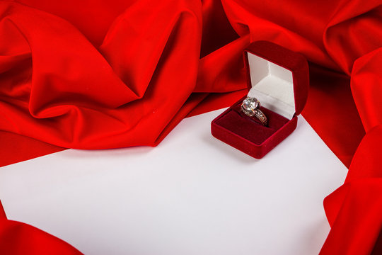 love card with diamond ring on a red fabric