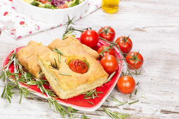 Fototapeta na wymiar Focaccia. italian bread slices with tomato and rosemary