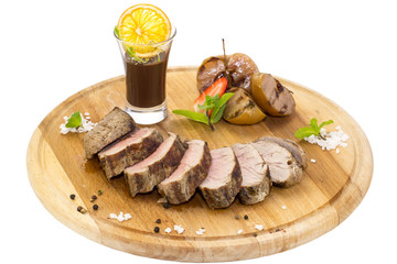 meat roasted on a grill with vegetables on a wooden plate