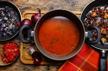 Pot of red soup on wooden table