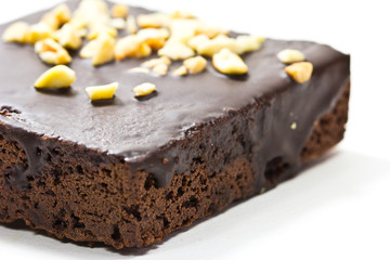 Frosted chocolate brownie on white background . Macro with extre